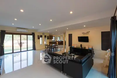 Spacious modern living room with sleek black furniture and large windows for natural light.