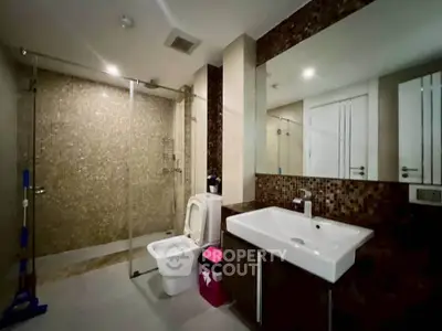 Modern bathroom with glass shower and sleek fixtures in a contemporary apartment.