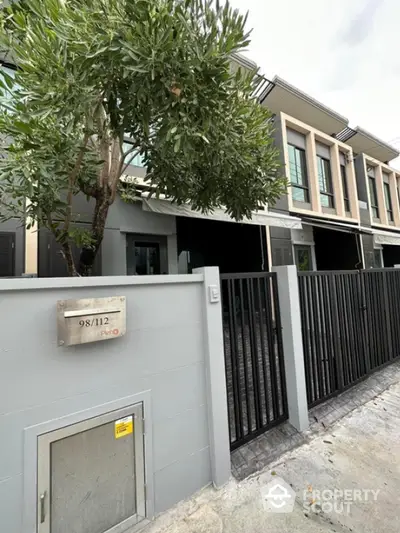 Modern townhouse exterior with sleek design and gated entrance