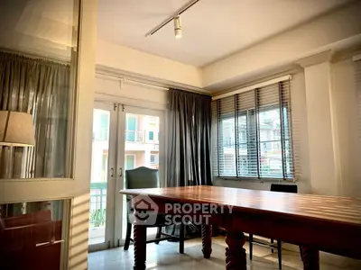 Elegant study room with large wooden table and natural light, perfect for productivity.