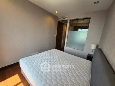 Spacious bedroom with natural light and modern decor in a stylish apartment.