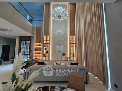 Luxurious modern living room with high ceilings and elegant chandelier