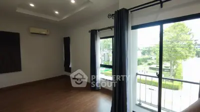 Spacious empty room with large windows and balcony access, perfect for customization.