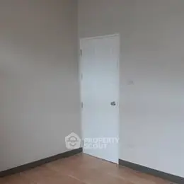 Minimalist empty room with wooden floor and white door