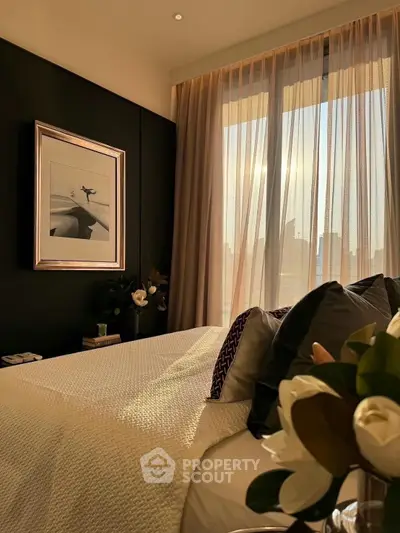 Luxurious bedroom with elegant decor and large window offering stunning city view.