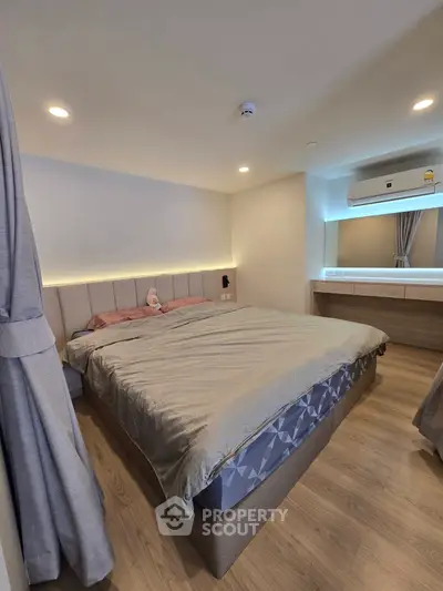 Modern bedroom with cozy lighting and stylish decor, featuring a large bed and elegant furnishings.