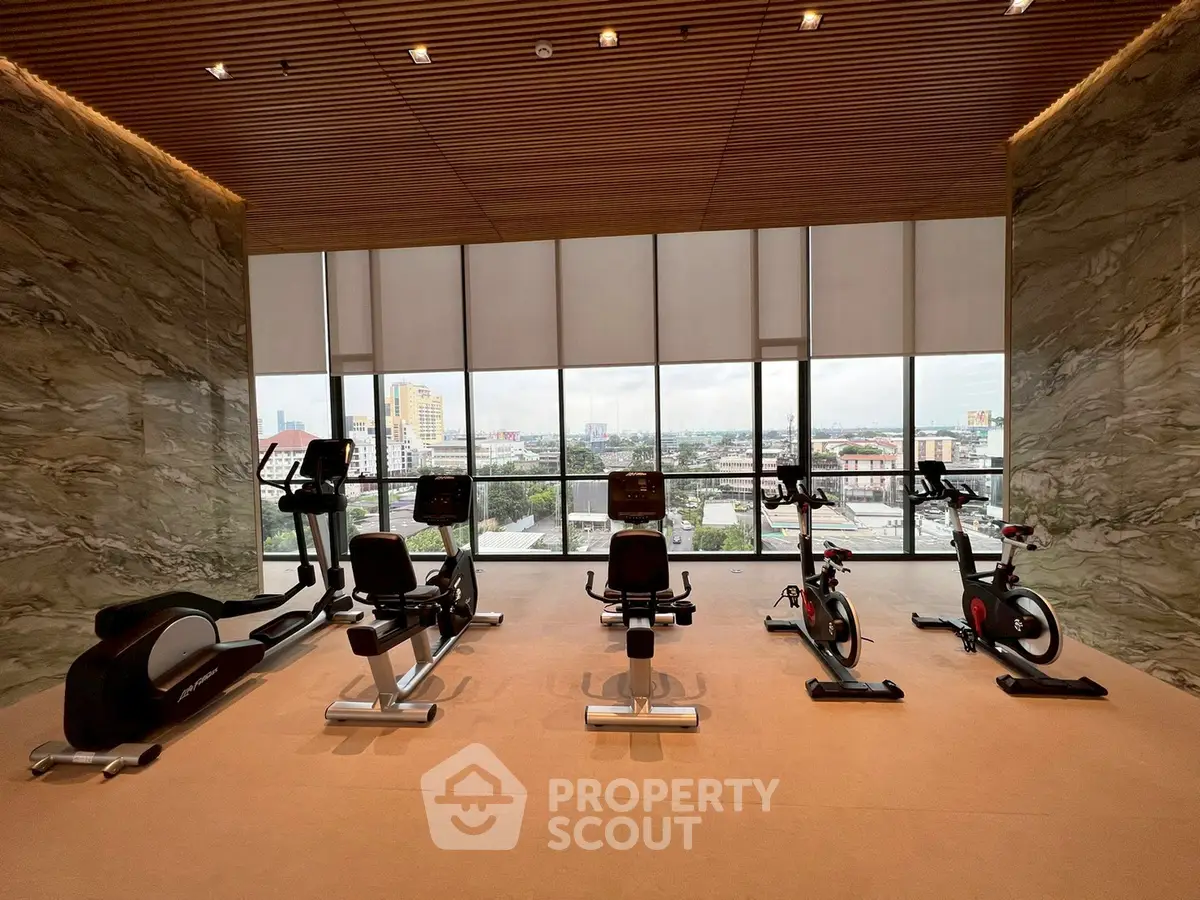 Luxurious gym with modern equipment and panoramic city views.