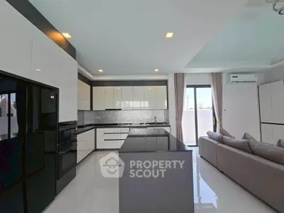 Modern kitchen with sleek black and white cabinetry, island, and open layout in a stylish apartment.