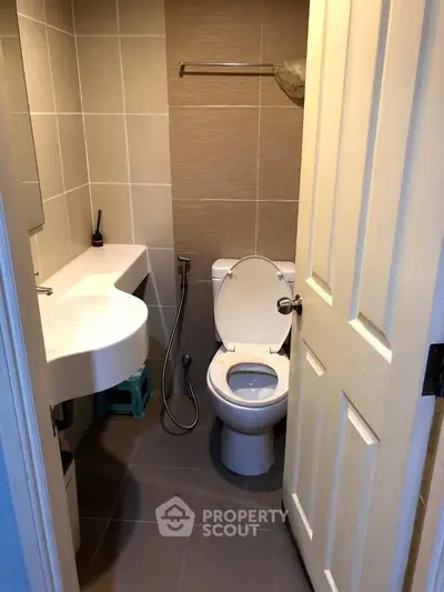 Compact bathroom with modern fixtures and neutral tile design