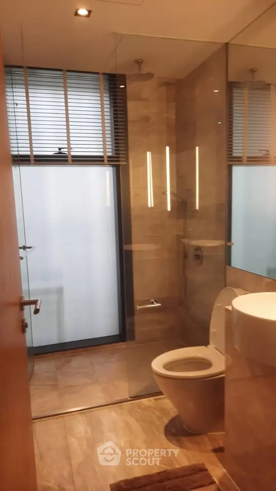 Modern bathroom with glass shower and sleek fixtures in a contemporary apartment.