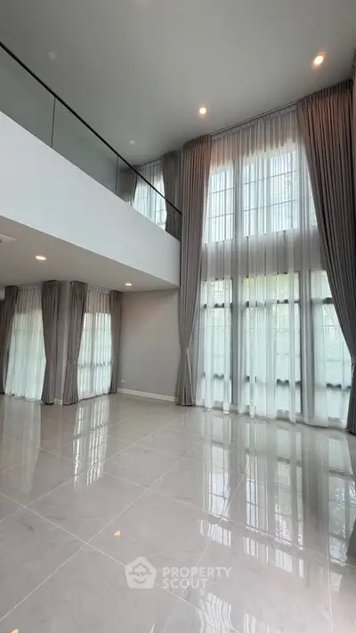 Spacious modern living room with high ceilings and large windows, perfect for natural light.