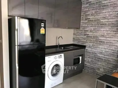Modern kitchen with sleek appliances and stylish brick wall design.
