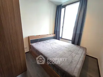 Modern bedroom with large window and stylish wooden furniture, perfect for natural light lovers.