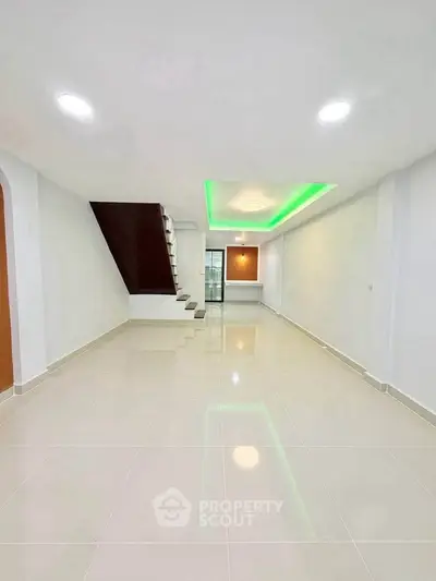 Spacious modern living room with sleek staircase and ambient lighting