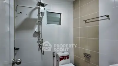 Modern bathroom with sleek shower and neutral tiles, perfect for a contemporary home.
