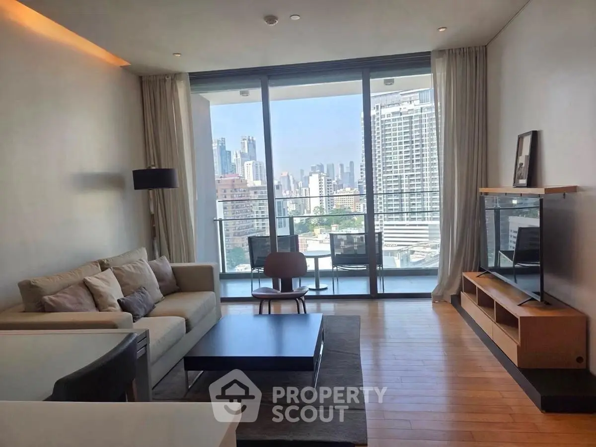 Modern living room with city view, featuring sleek furniture and floor-to-ceiling windows.