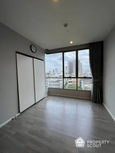 Spacious empty room with large windows offering stunning city views, perfect for customization.