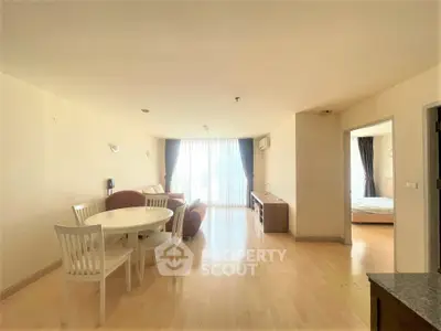 Spacious open-plan living and dining area with natural light and modern furnishings.