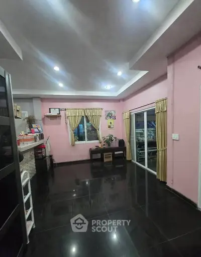 Spacious living room with modern black tile flooring and elegant curtains