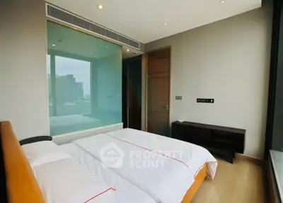 Modern bedroom with large window and city view, featuring sleek design and natural light.