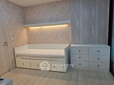 Modern bedroom with stylish bed and dresser, featuring elegant lighting and wood panel accents.