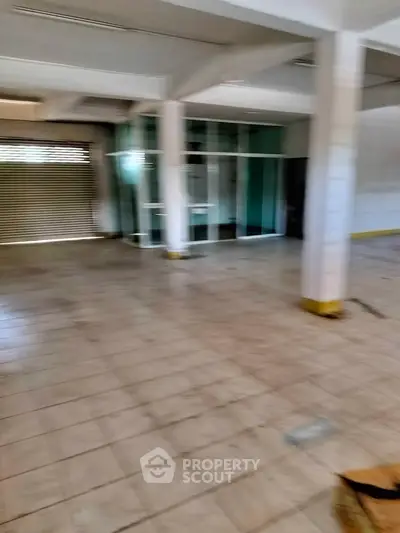 Spacious commercial space with tiled flooring and glass partition, ideal for business setup.