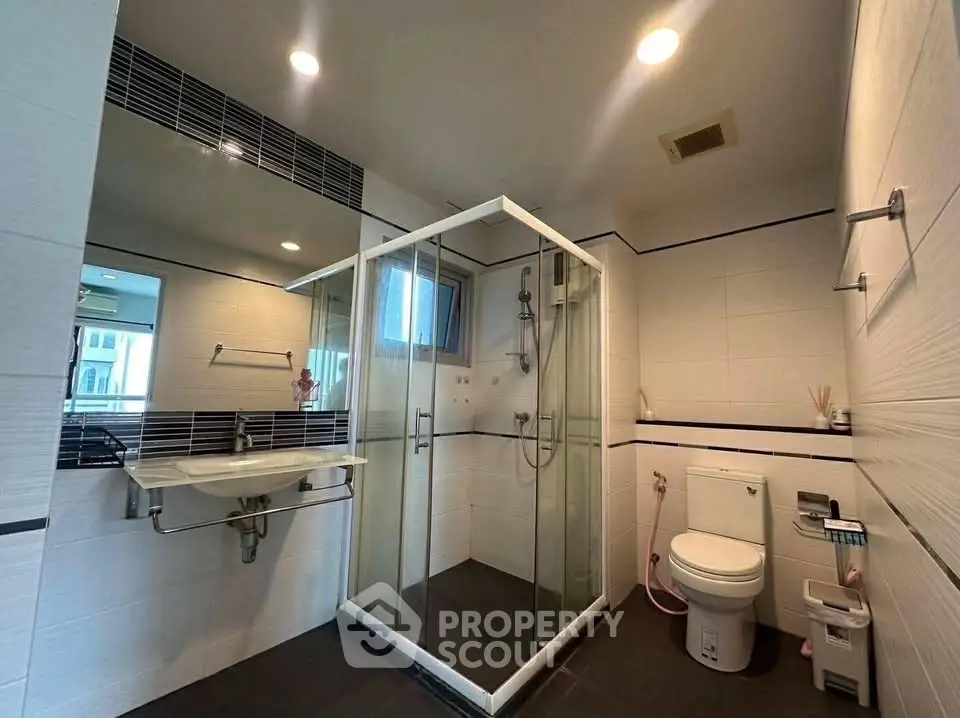 Modern bathroom with glass shower and sleek fixtures in a contemporary home.