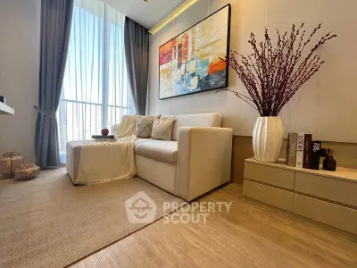 Elegant living room with modern decor, large window, and cozy seating area.