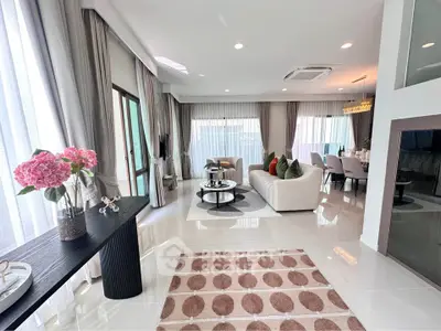 Luxurious open-plan living room with elegant decor and ample natural light.