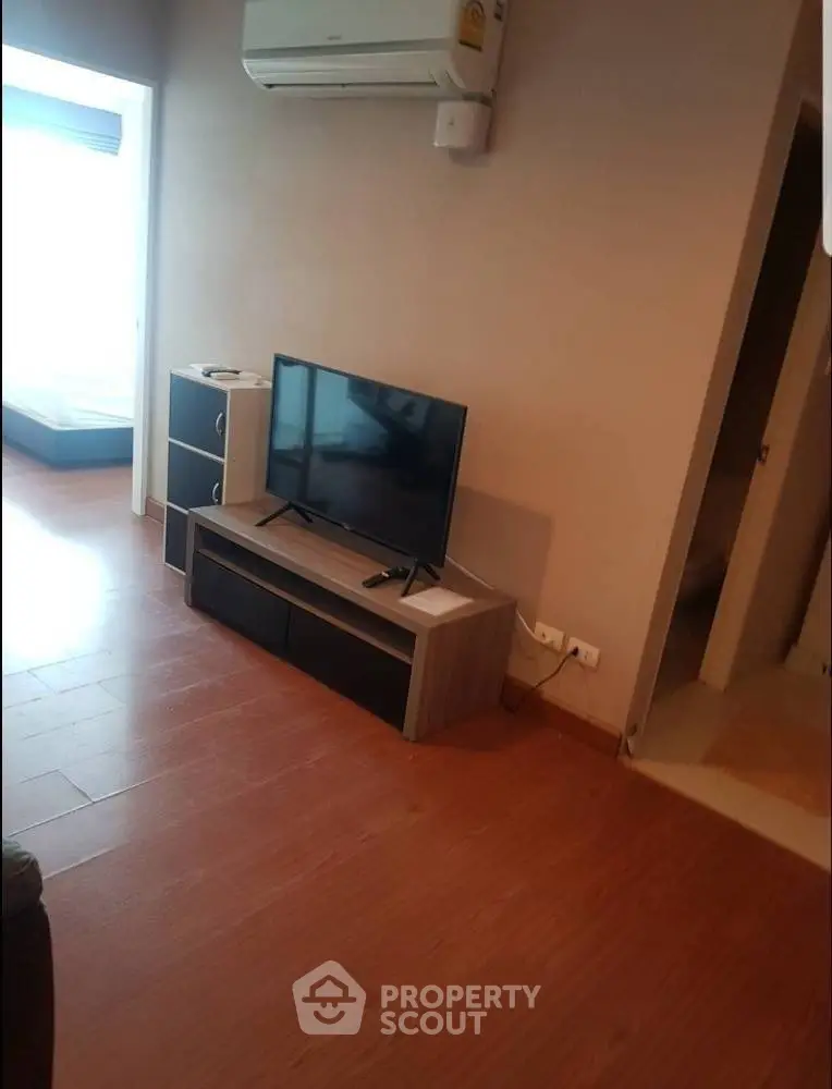Modern living room with sleek TV stand and air conditioning unit, perfect for cozy relaxation.
