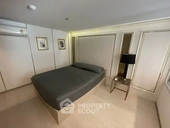 Modern bedroom with sleek design and neutral tones, featuring a comfortable bed and stylish decor.