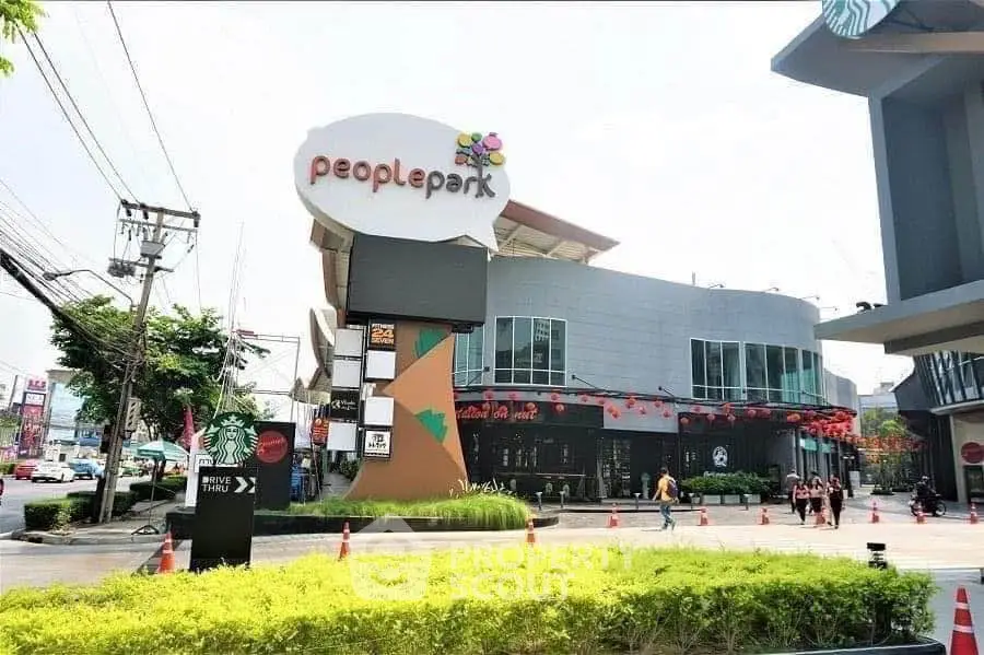Modern commercial building exterior with vibrant signage and lush landscaping.