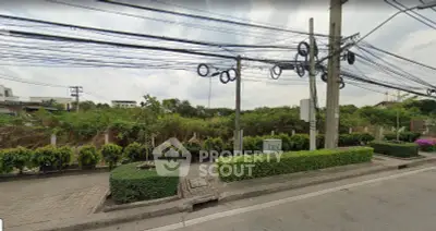 Vacant land plot with lush greenery and potential for development in a serene neighborhood.