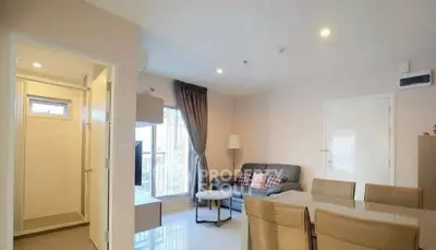 Modern living room with cozy seating and dining area, bright natural light.