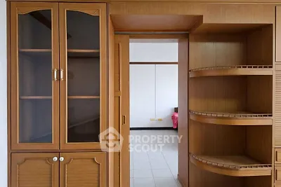 Spacious wooden storage unit with open shelves and glass cabinets in a modern interior.