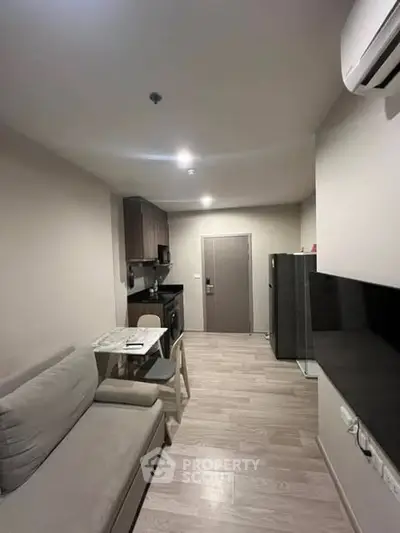 Modern apartment interior with cozy living area and compact kitchen.