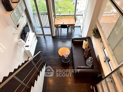 Stunning modern living room with high ceilings and balcony view, perfect for urban living.