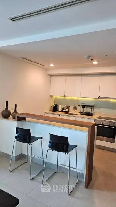 Modern kitchen with sleek design, featuring an open layout and stylish bar seating.