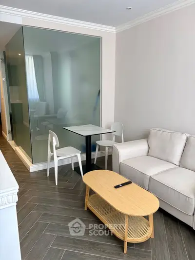 Modern living room with sleek furniture and glass partition, perfect for stylish urban living.