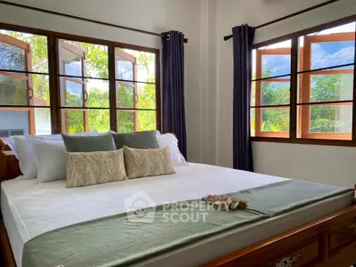 Bright and airy bedroom with large windows and cozy decor