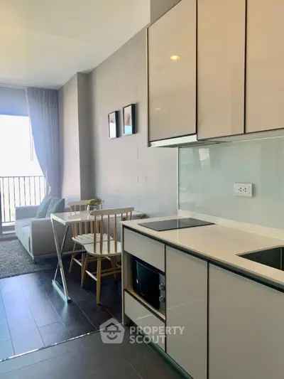 Modern open-layout kitchen and living area with sleek design and natural light.