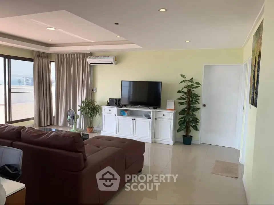 Spacious living room with modern decor and large windows offering ample natural light.