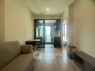 Modern living room with open kitchen and balcony view in a stylish apartment.