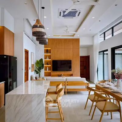 Modern open-plan living room and kitchen with stylish decor and natural light