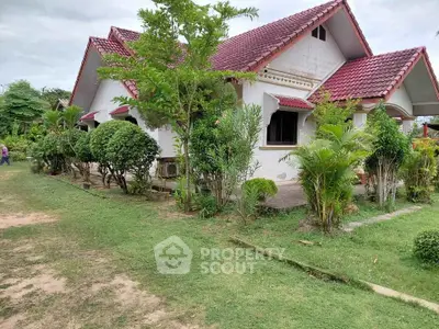 Charming suburban house with red roof and lush garden, perfect for family living.