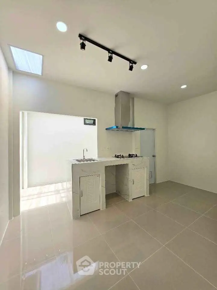 Modern minimalist kitchen with sleek design and ample natural light.