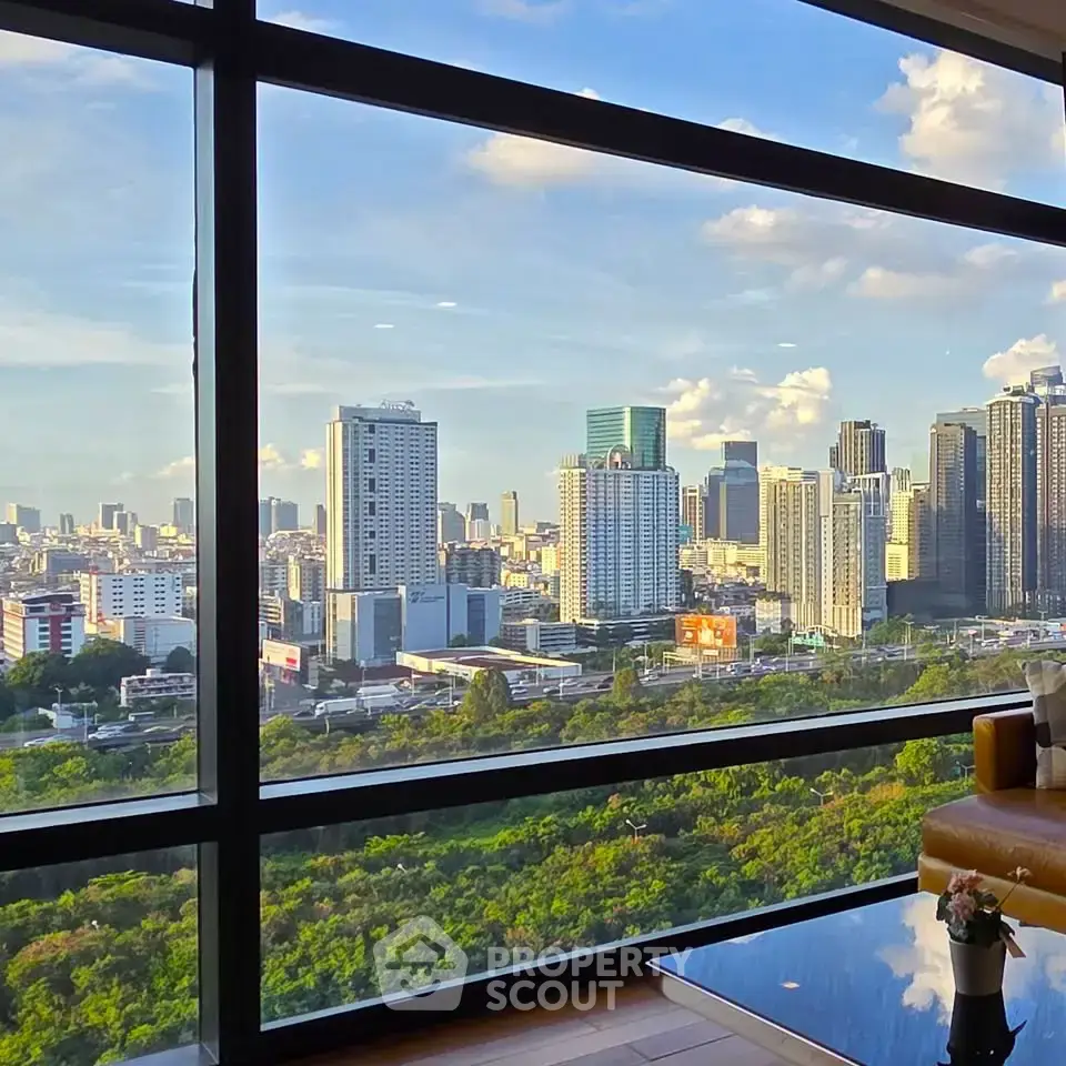 Stunning cityscape view from high-rise apartment window with lush greenery and skyline.