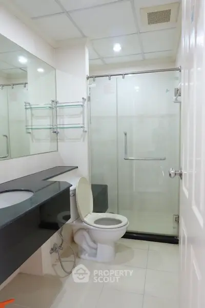 Modern bathroom with glass shower and sleek black countertop