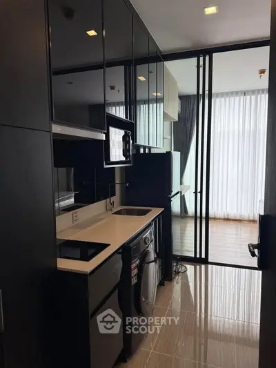 Modern kitchen with sleek cabinetry and integrated appliances in a stylish apartment.