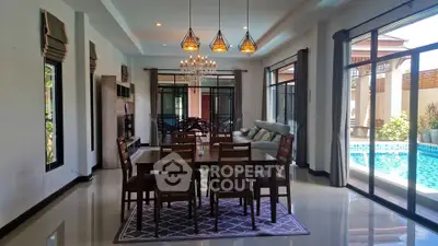Luxurious dining area with pool view, elegant lighting, and spacious layout in modern home.